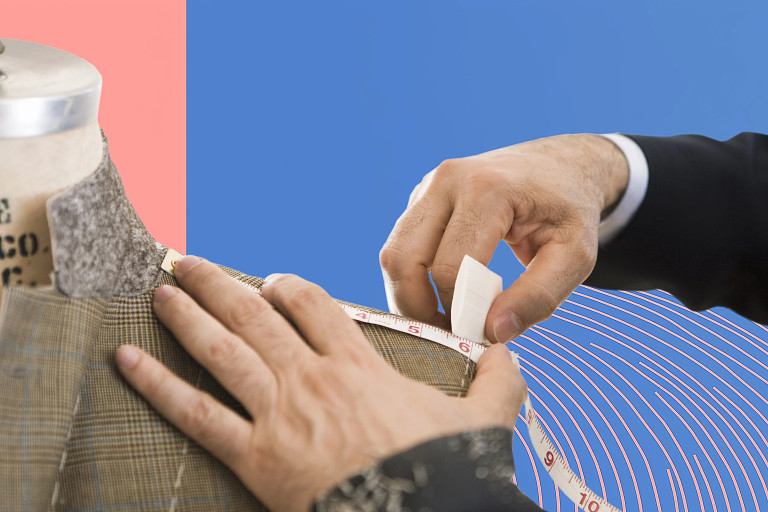 The image features a close-up of a tailor measuring a suit on a dress form. A hand, wearing a formal black suit, is seen adjusting a measuring tape around the shoulder area of the garment.